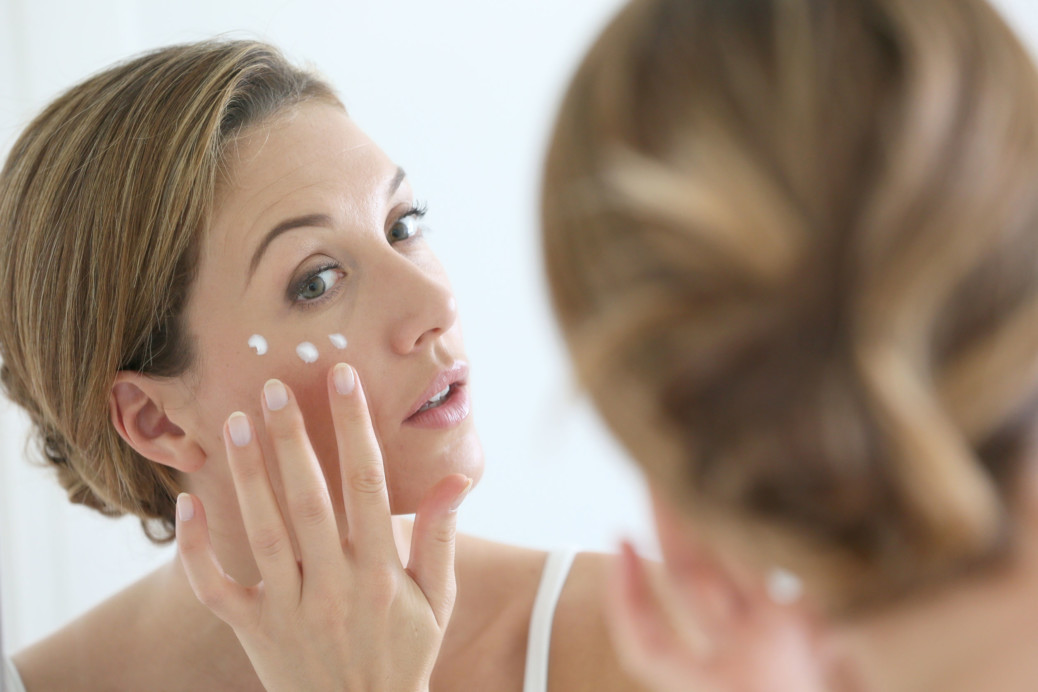 Middle-aged woman applying anti-aging cream